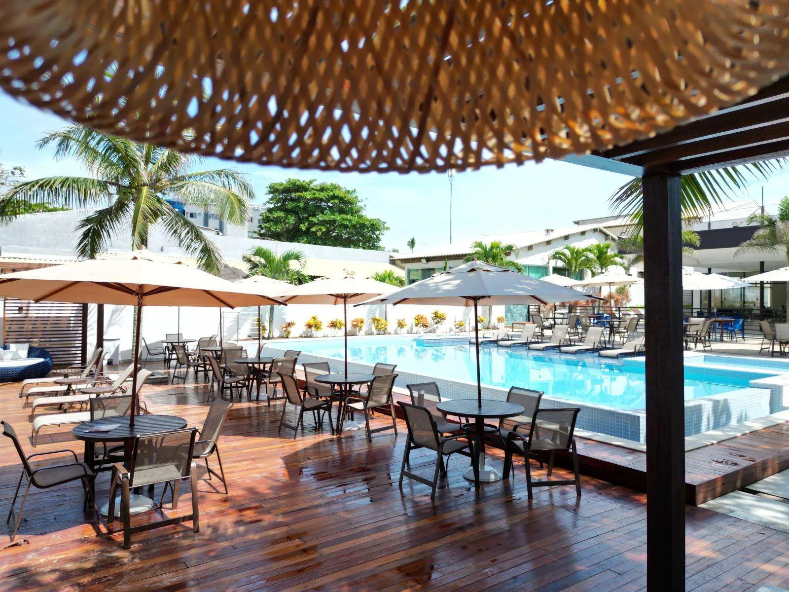 Área lounge sob cobertura ao lado da piscina